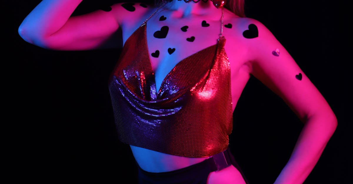 Stylish woman posing in neon lights, wearing heart patterns and futuristic glasses.