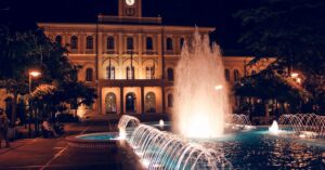 A stunning nighttime scene of an illuminated fountain and architectural facade in Ohlstadt, Germany.